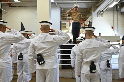 Marine 2nd Lieutenant Colin DuPont instructs incoming plebes on how to salute.