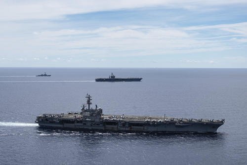 In this July 6, 2020, file photo provided by U.S. Navy, the USS Ronald Reagan (CVN 76, front) and USS Nimitz (CVN 68, rear) Carrier Strike Groups sail together in formation, in the South China Sea. (Mass Communication Specialist 3rd Class Jason Tarleton/U.S. Navy via AP, File)