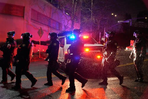 Portland police officers walk outside the U.S. Immigration and Customs Enforcement facility on Thursday, Jan. 8, 2026, in Portland, Ore. (AP Photo/Jenny Kane)