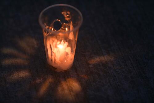 A candle burning in a cup.
